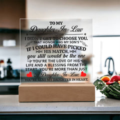 Clear acrylic plaque with a heartfelt message for a daughter-in-law, illuminated by a warm LED light on a wooden base, displayed on a kitchen counter.