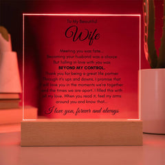 Square acrylic plaque with a heartfelt anniversary message to a wife, illuminated by a warm wooden base, perfect as a sentimental gift for special occasions.