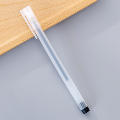 Slim translucent pen with a minimalist design resting beside a wooden surface, featuring a white clip and black tip for smooth, precise writing.