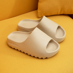Beige platform beach sandals with open toe and cushioned sole, designed for comfort and casual wear, displayed on a mustard-yellow fabric surface.
