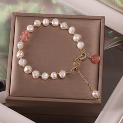 Delicate adjustable bracelet featuring irregular white freshwater pearls and soft pink jade beads accented with small gold spacer beads, displayed on a taupe gift box.