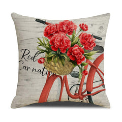 Decorative throw pillow featuring a vintage red bicycle with a basket full of vibrant red carnations against a rustic wood background, perfect for home décor.