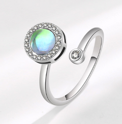 Elegant adjustable white gold ring featuring a rotatable opalescent center stone surrounded by small sparkling crystals, perfect for statement jewelry lovers.