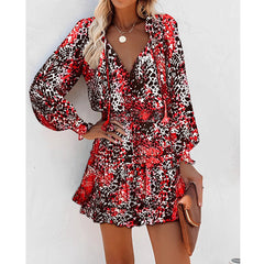 Woman wearing a stylish long sleeve floral and animal print dress with puffed sleeves and a waist-defining silhouette, accessorized with a necklace and a brown clutch purse.
