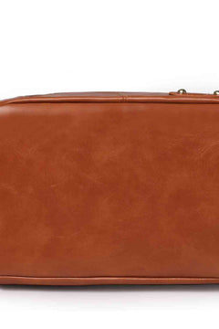 Brown vegan leather surface close-up of a luxury travel and commuter bag with smooth texture and subtle natural grain detailing.
